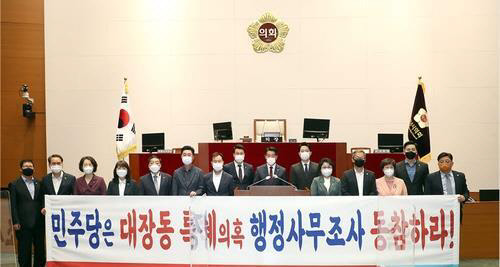 성남시의회 의원들이 최근 시의회에서 더불어민주당에 대장동 특혜 의혹과 관련한 행정사무조사에 동참하라는 플래카드를 들고 있다.